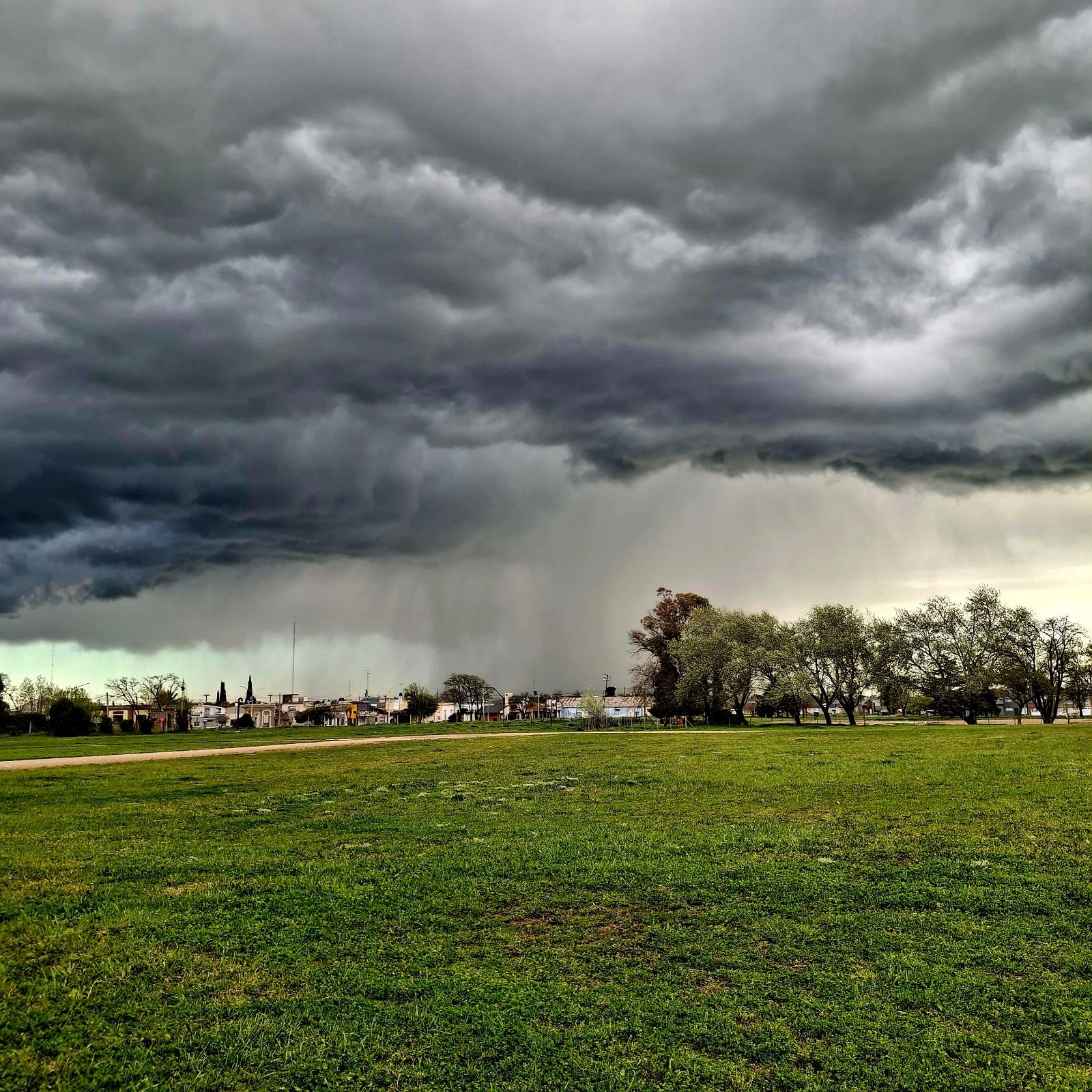 Cortina de lluvia bajo un frente de tormenta, detrás del pueblo.